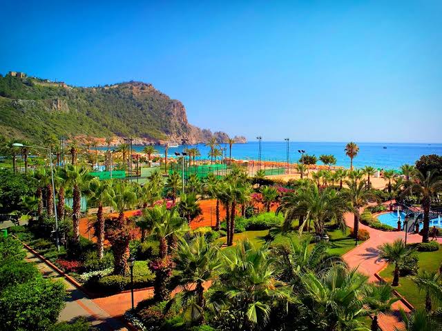 Luksuzni All Inclusive hotel sa bazenom i palmama blizu plaže u Alanji, Turska